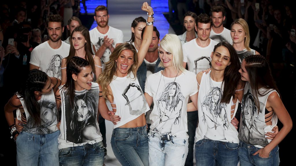 Model Gisele Bundchen reacts as she and other models present creations from the Colcci Summer 2016 collection during Sao Paulo Fashion Week in Sao Paulo