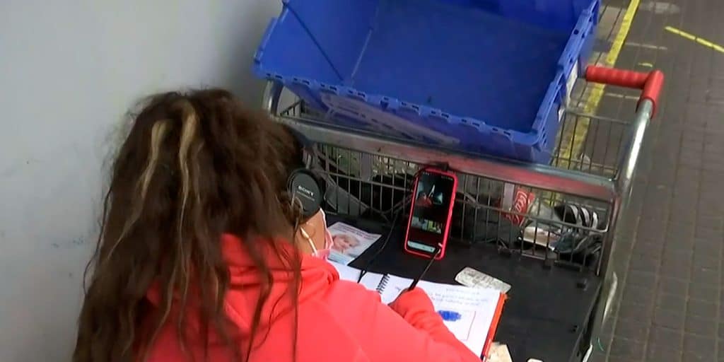 Niña recibe clases online en la calle junto a su madre vendedora ambulante