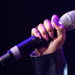 Female Hand Holds A Wireless Microphone