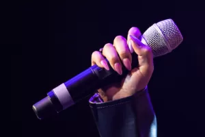 Female Hand Holds A Wireless Microphone